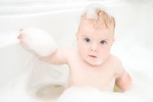 15042694 - mother washing baby hair in bath.